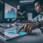 Homme appuyant sur une tablette avec des graphiques