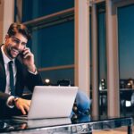 Un homme au téléphone devant PC