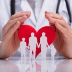 homme qui entoure de ses mains un coeur et une famille