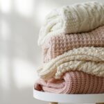 pulls en laine superposés sur une petite table