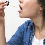 Femme prend des gouttes d&rsquo;huile