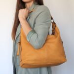 femme portant un sac surl’épaule marron clai$