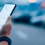 homme qui tient son téléphone et regarde l’évolution de la bourse