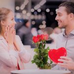 happy couple with present and flowers in mall