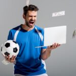 Un homme avec un PC et un ballon de foot