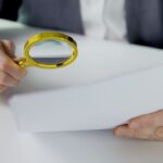 Homme regarde un document avec une loupe