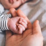 La main d’un bébé dans la main d’adulte