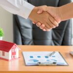 Poignée de mains et maison miniature