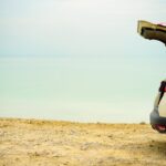 Summer vacation and holiday. Travel, adventure concept. White crossover car on beach road. Digital detox.