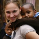 bénévole en mission humanitaire qui porte un enfant