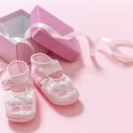 It’s a girl announcement. Baby girl pink shoes on pink color background. Baby shower, christening concept.