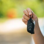 girl sitting in the car and holding the car keys