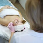 Cosmetologist does face peeling of a beautiful woman. Women’s cosmetology in the beauty salon