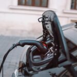 Power supply for hybrid electric car charging battery on urban europe street with blurred nature background. Eco car concept. Technology industry transport
