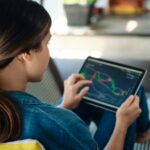 femme qui regarde l’évolution de la bourse sur sa tablette