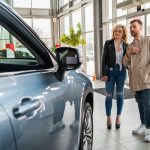 Beautiful couple in car dealership chooses car